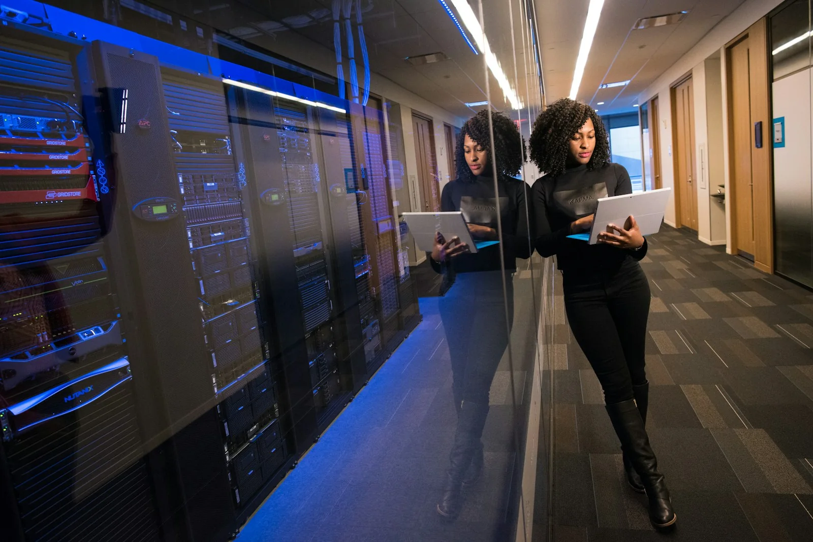 Infrastructure engineer inspecting live server systems with a tablet
